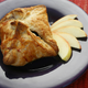 Apple dumpling on a plate beside sliced apples